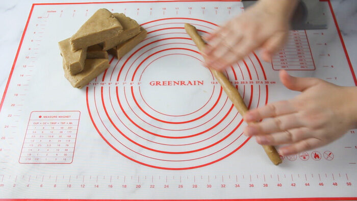 Rolling peppernut dough out into ropes before cutting