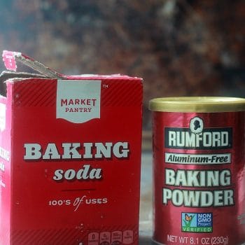 Box of baking soda and a can of baking powder side by side