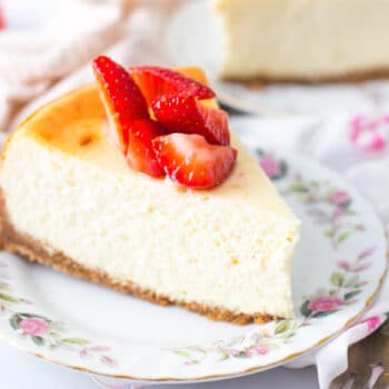 Slices of New York Style cheesecake plated up with fresh strawberries