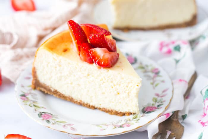 Slice of New York Style Cheesecake plated up with fresh strawberries