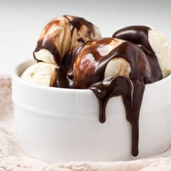 Hot fudge poured over a bowl of ice cream
