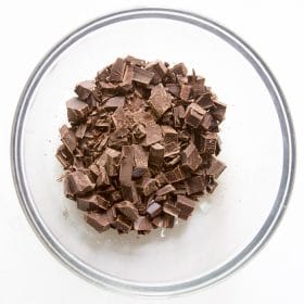 Cut up chocolate in glass bowl