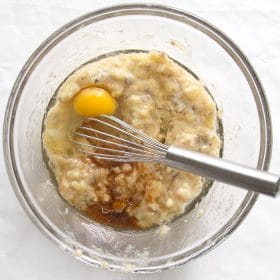 All wet ingredients added to the bowl of mashed banana