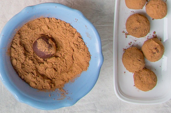 This is a recipe for French chocolate truffles, which is a very simple yet decadent dessert. This style of dessert truffles are made with only three ingredients: melted chocolate, cream, and cocoa powder. Learn the process of how to make chocolate truffles for an easy yet impressive dessert! Truffles being rolled in cocoa powder