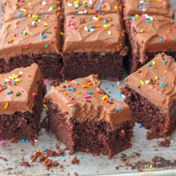 A chocolate sheet cake which chocolate frosting cut into squares
