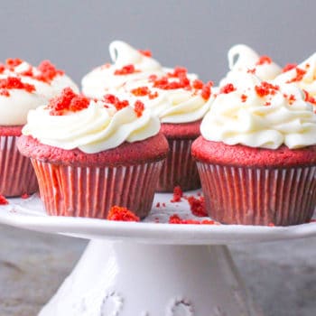 Red velvet cupcakes on a plate beautifully decorated with cream cheese frosting
