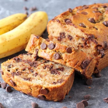 Chocolate chip banana bread sliced with chocolate chips scattered beside it