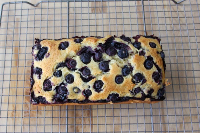 Cooked blueberry bread on a cooling rack before being glazed