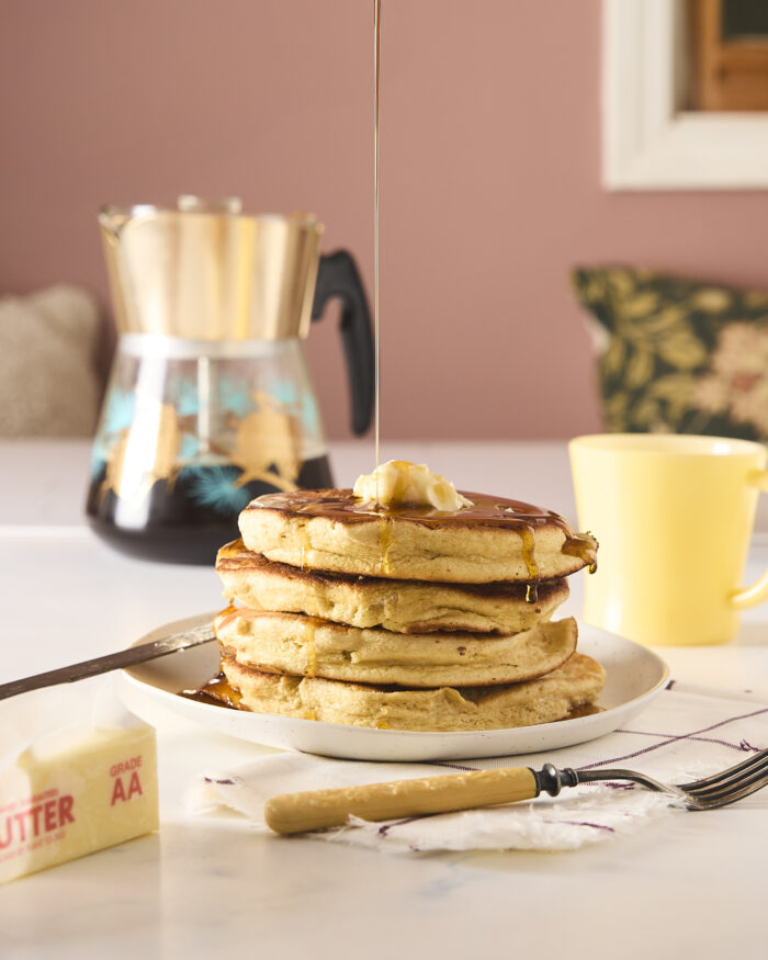 pouring syrup over pancakes