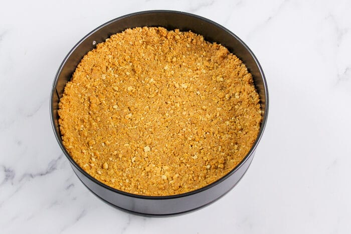 Graham cracker crust pressed into sprig form pan and ready to bake