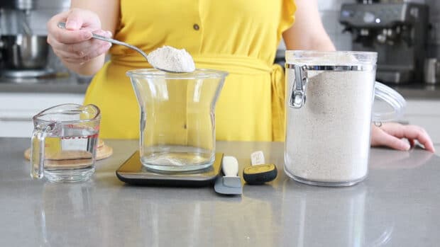 Measuring flour into the jar for day 1 of starting the sourdough starter