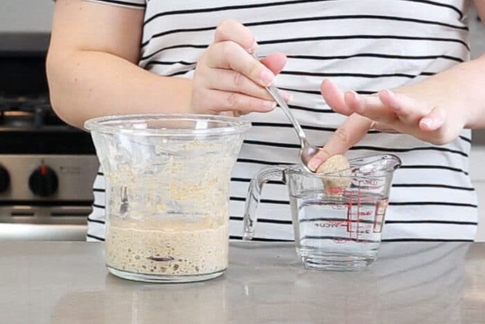 Demonstrating the float test by dropping some starter into a glass of water