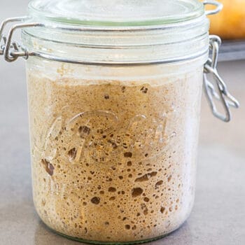 A jar of sourdough starter that is filled with bubbles