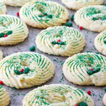 Butter Spritz cookies decorated to look like a wreath all lined up for a beauty shot