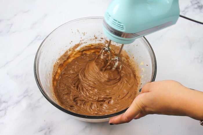 Final chocolate whoopie pie batter being mixed with a hand mixer. The mixture is smooth and chocolate in color