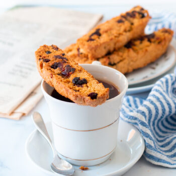 Cranberry Orange biscotti resting on a cup of coffee