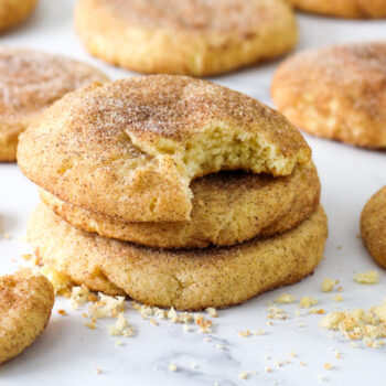 Snickerdoodles on a sheetpan, one with a bite taken out