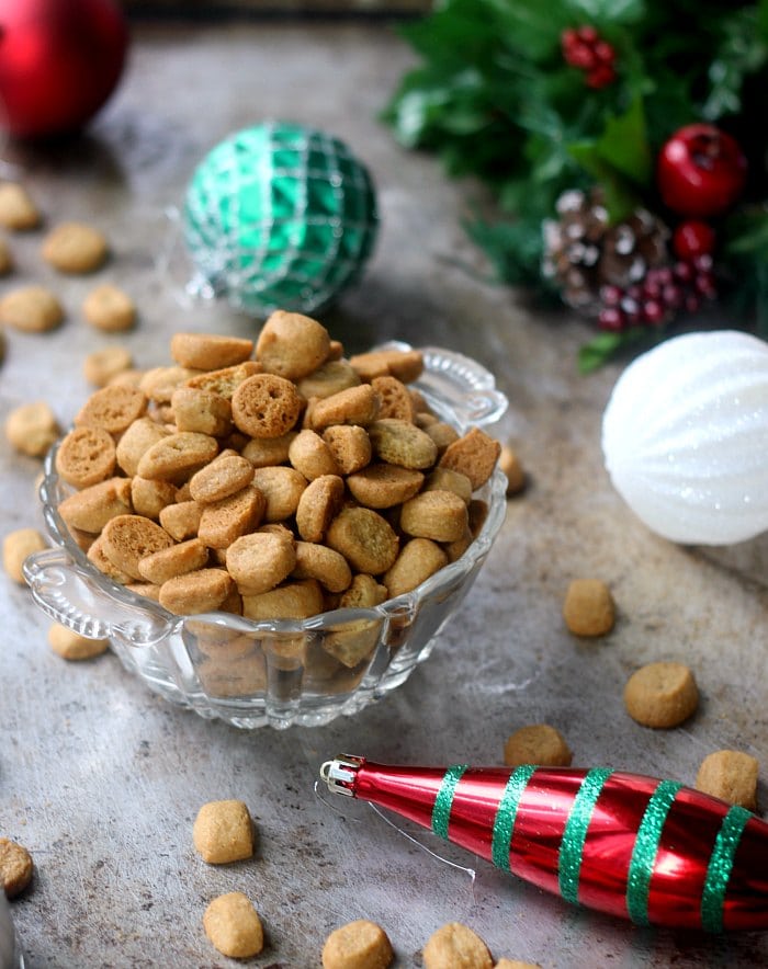 Peppernut cookies in a candy bowl surrounded by holiday ornaments