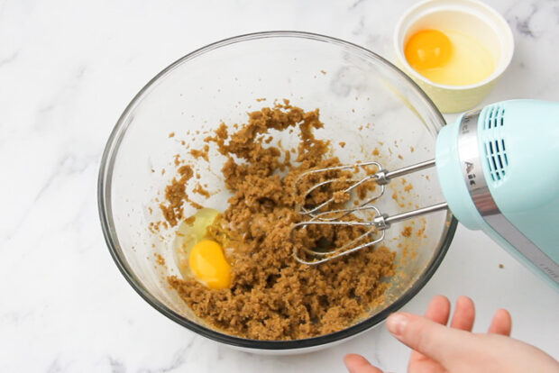 Showing adding eggs into bowl for cookie dough