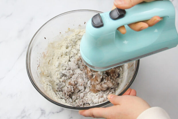 Using a hand mixer to mix in the flour for the spicy chocolate cookie dough