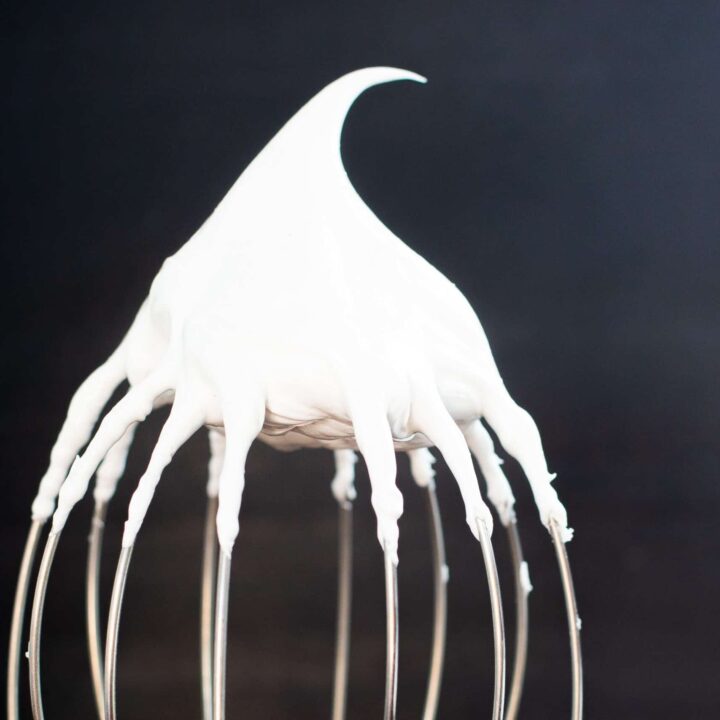 Stiff meringue on a whisk holding its peak