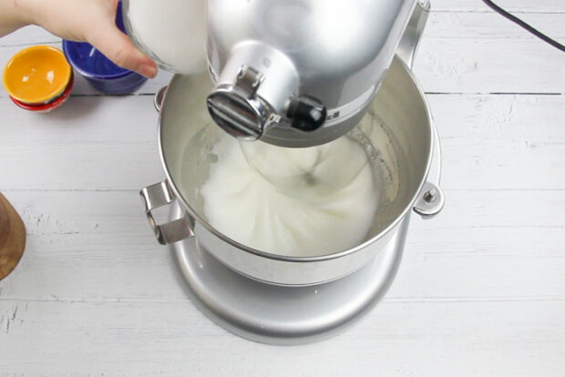 Slowly streaming sugar into the egg whites