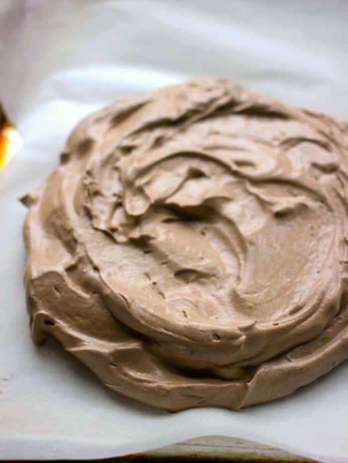Chocolate meringue spooned into a disk