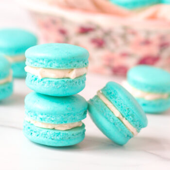 Stack of french macarons with a bowl of macarons in the back