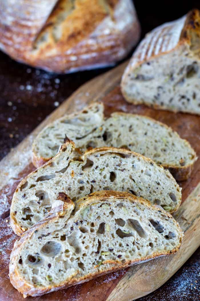 Slices of sourdough bread lined up on a wooden cutting board
