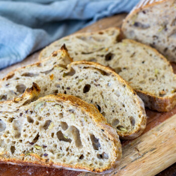 Slices of sourdough bread lined up on a wooden cutting board