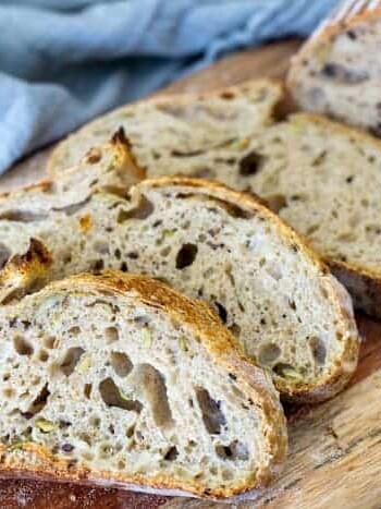 Slices of sourdough bread lined up on a wooden cutting board