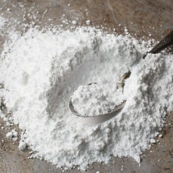 Pile of homemade powdered sugar with a spoon scooping some up