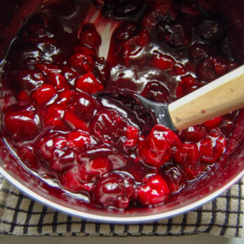 Cooked cherry syrup on the stovetop in a saucepan