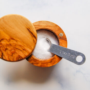 Wooden container of salt and measuring spoon