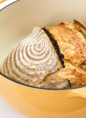 loaf of baked sourdough in a dutch oven