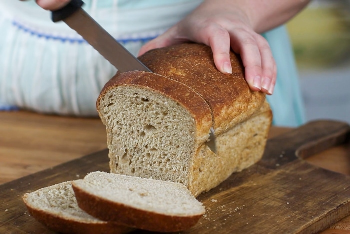 Slicing honey wheat sourdough sandwich bread