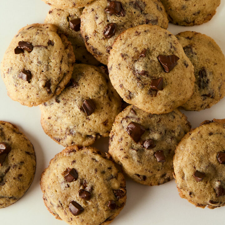 mini chocolate chip cookies piled on a counter