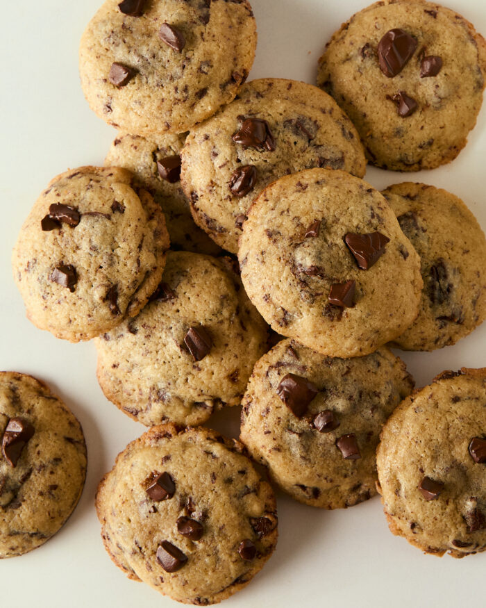 mini chocolate chip cookies piled on a counter