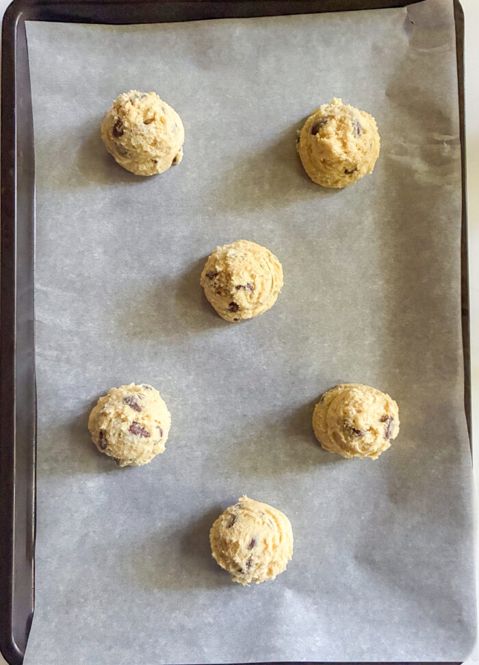 scooped cookie dough balls on a baking sheet ready to be baked