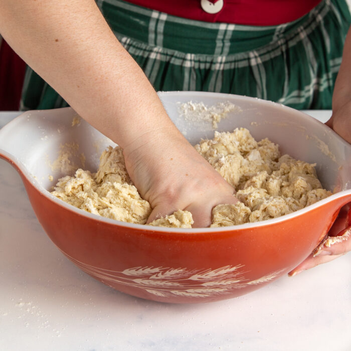 Using hands to mix up the ingredients