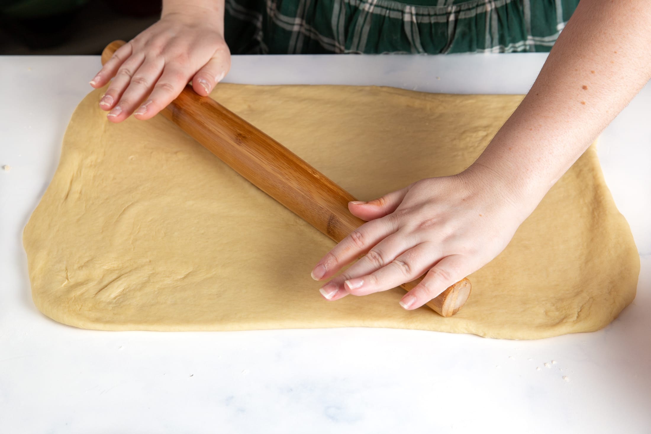 Dough being rolled into a large rectangle