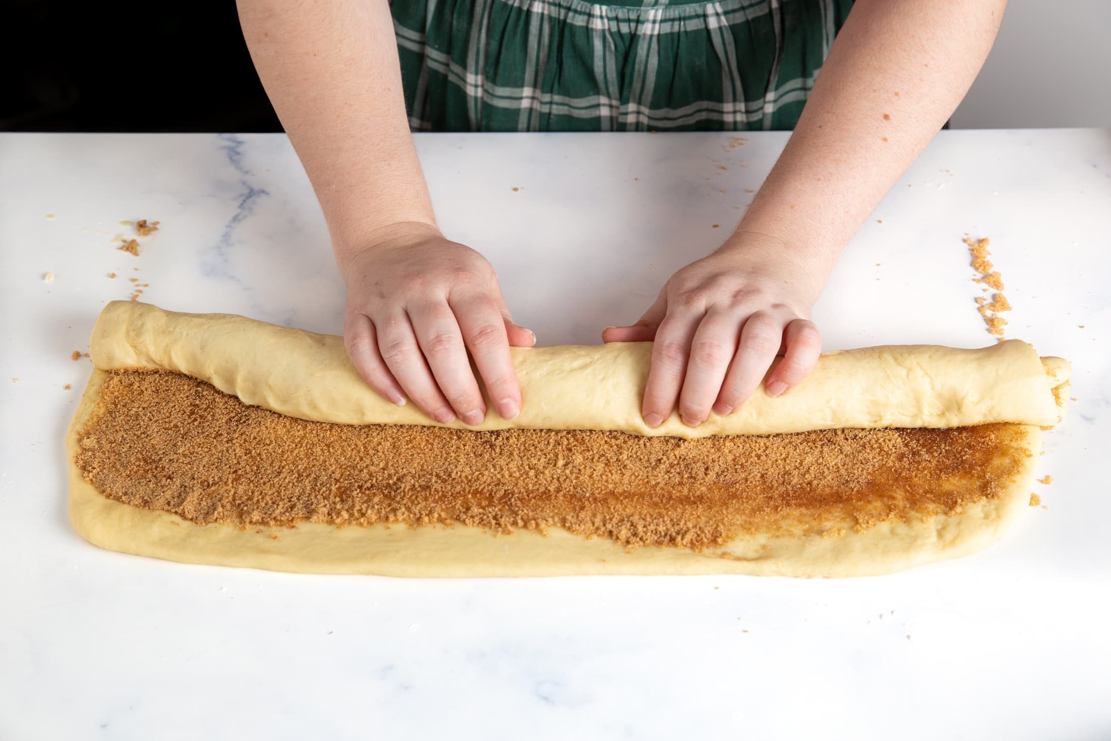 After filling with butter, cinnamon, and sugar, roll up the dough on the long end