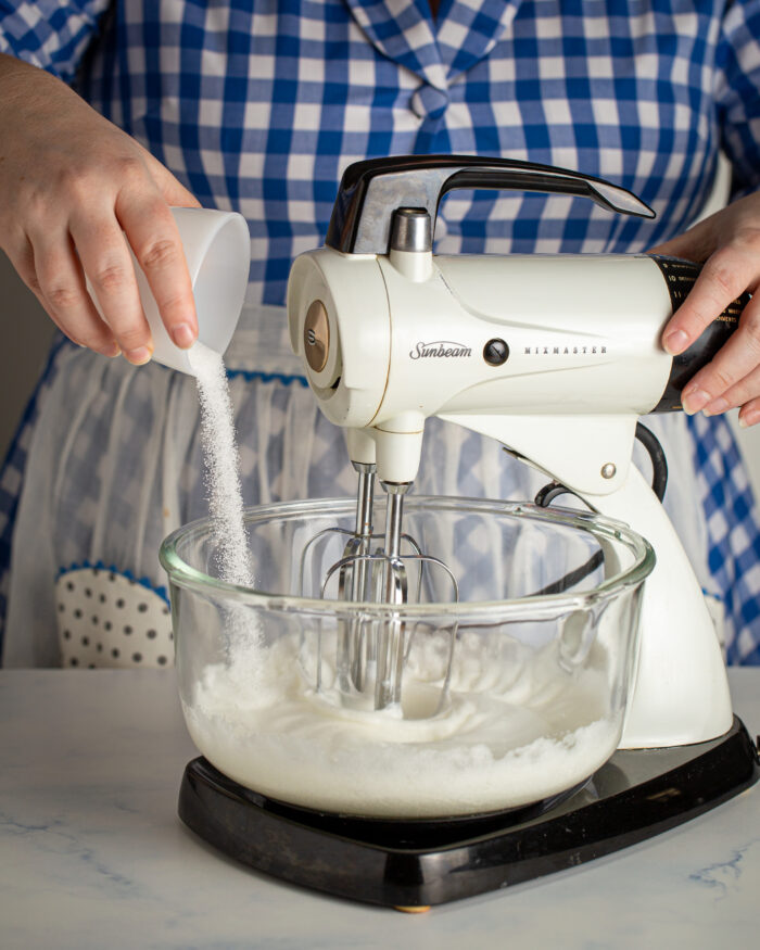 Whipping egg whites with a little sugar to make meringue