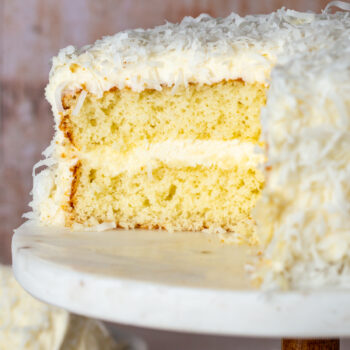A 2 layer coconut cake with a slice taken out