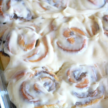 Gooey Cinnamon Rolls in a casserole dish slathered with cream cheese frosting