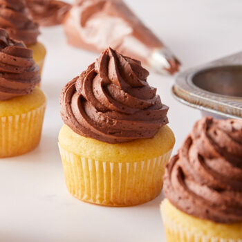 vanilla cupcakes topped with chocolate buttercream frosting