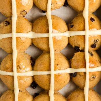 closeup of baked and iced hot cross buns