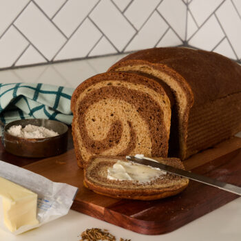 a loaf of marbled rye bread being sliced