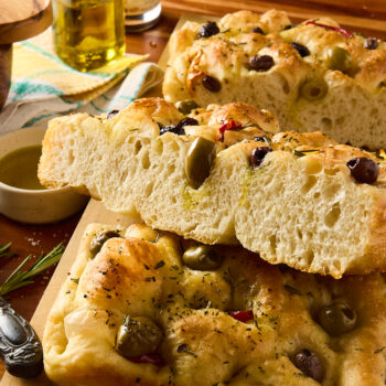 sourdough focaccia bread cut into a large piece to see the airy inside